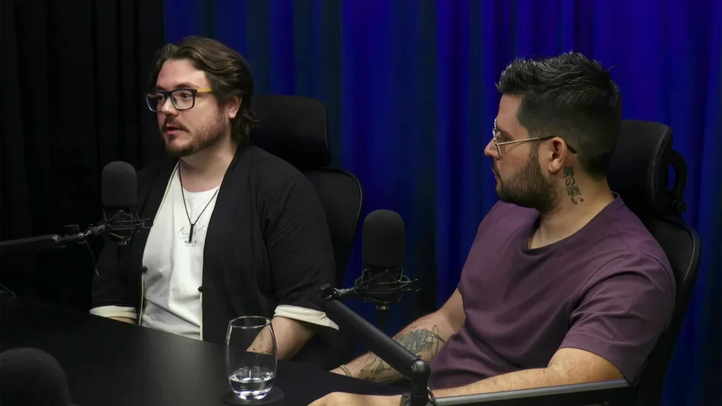 Eron Greco, CTO do Chatspot, e Thiago Xavier, CMO do Chatspot, conversando em estúdio de podcast com microfones profissionais e cortina azul ao fundo, durante gravação sobre agentes de inteligência artificial, integrações por API e automação de atendimento pelo WhatsApp